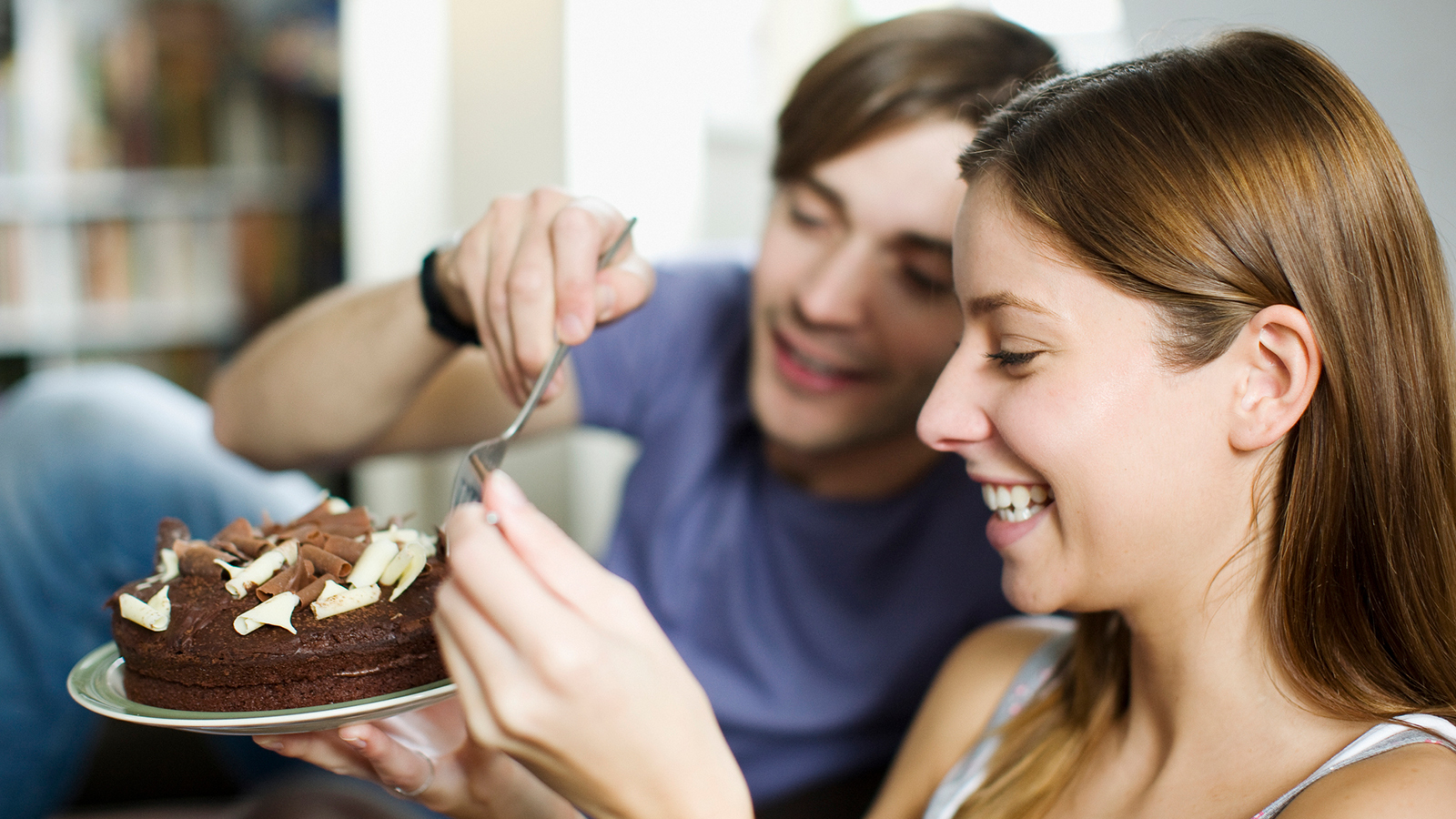 A couple eat cake together