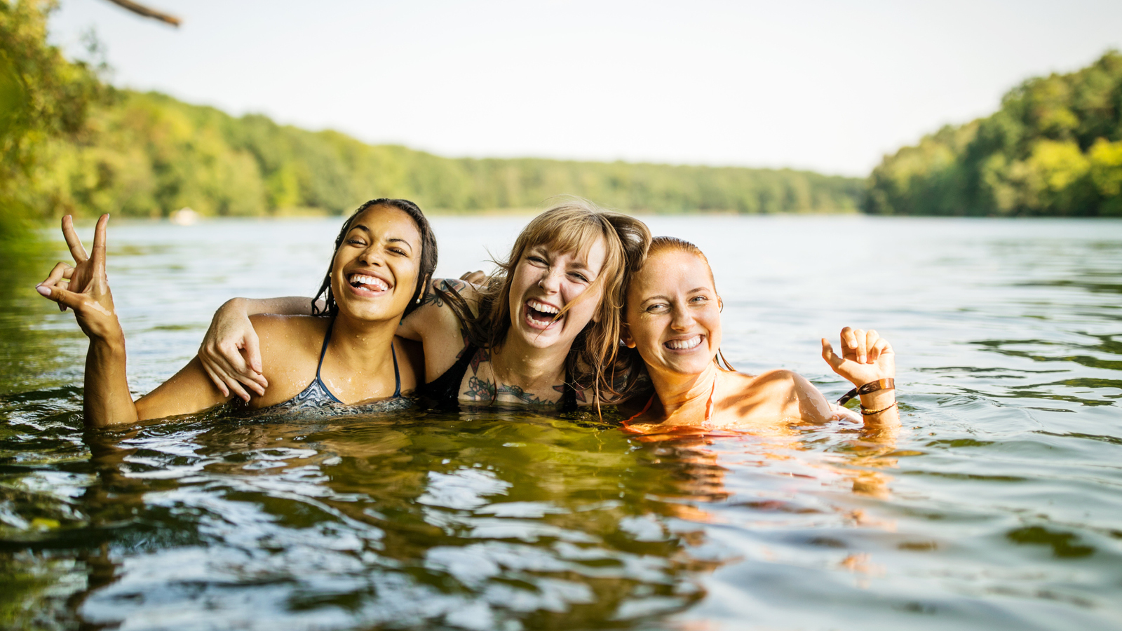 3 women swimming in a lake