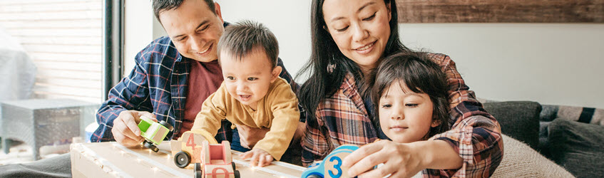 A family playing with wooden toy cars