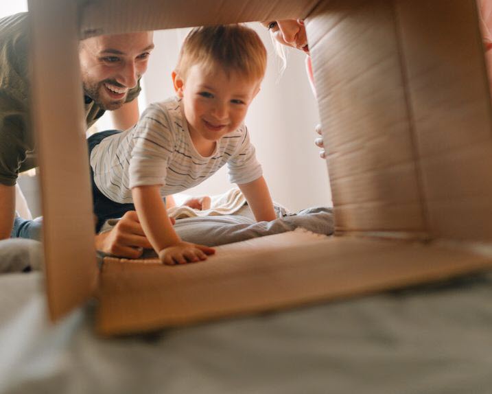 Southern Cross Life Insurance - member offer A mother and father and their child playing pretend with a cardboard box