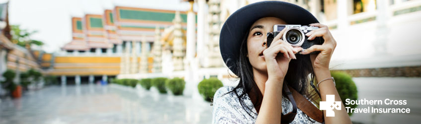 A woman on holiday in Asia, taking a photo of her surroundings