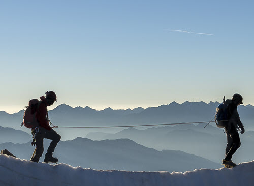 Trust Centre - security Two men walking on a mountain tethered by a security line