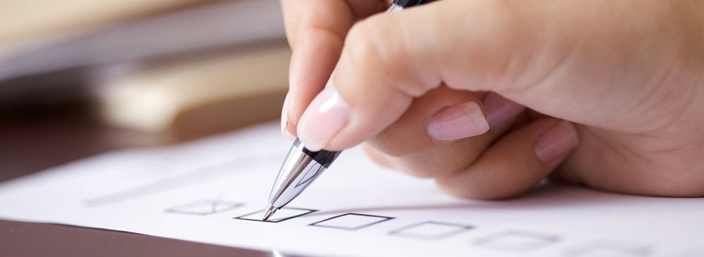 A hand ticking a box on a form