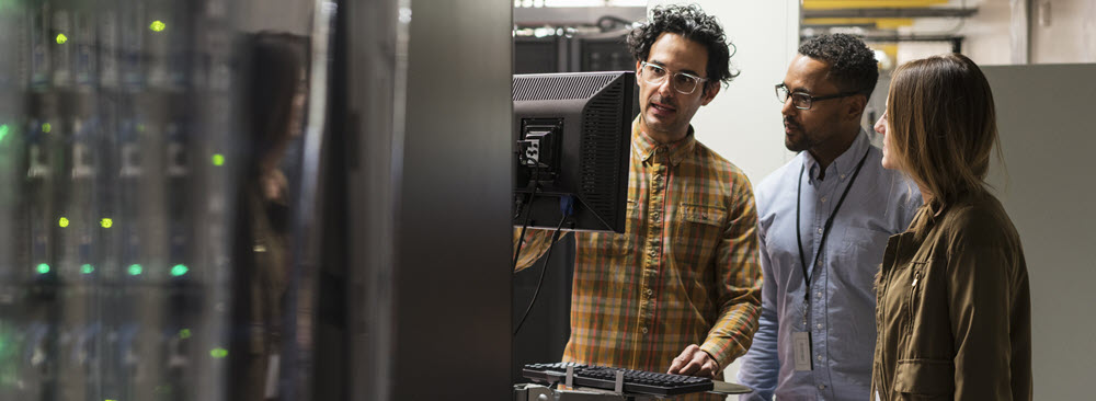 Work colleagues standing at a computer station